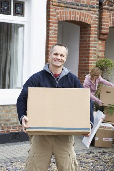 Removal team loading household items into a moving vehicle