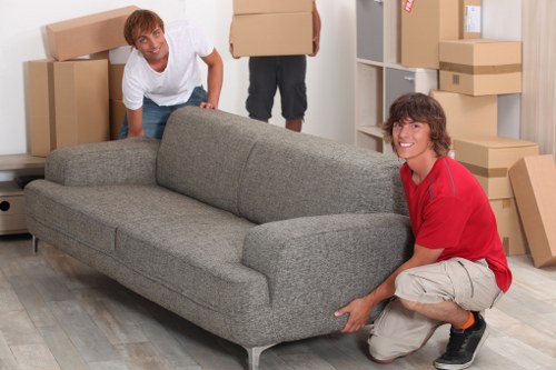 Removal team handling a sofa and large items on a Kennington street